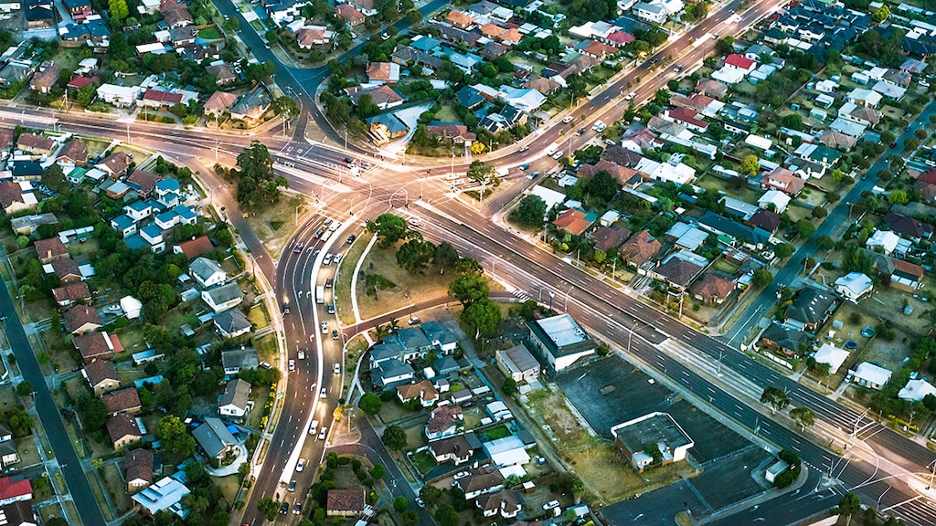 Aerial view of major roads cutting through housing developments in suburban Melbourne, Australia.